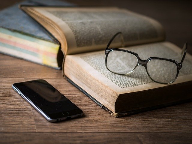brýle a telefon u knihy