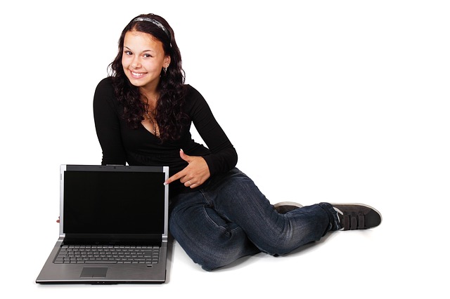 děvče, které ukazuje na počítač a usmívá se